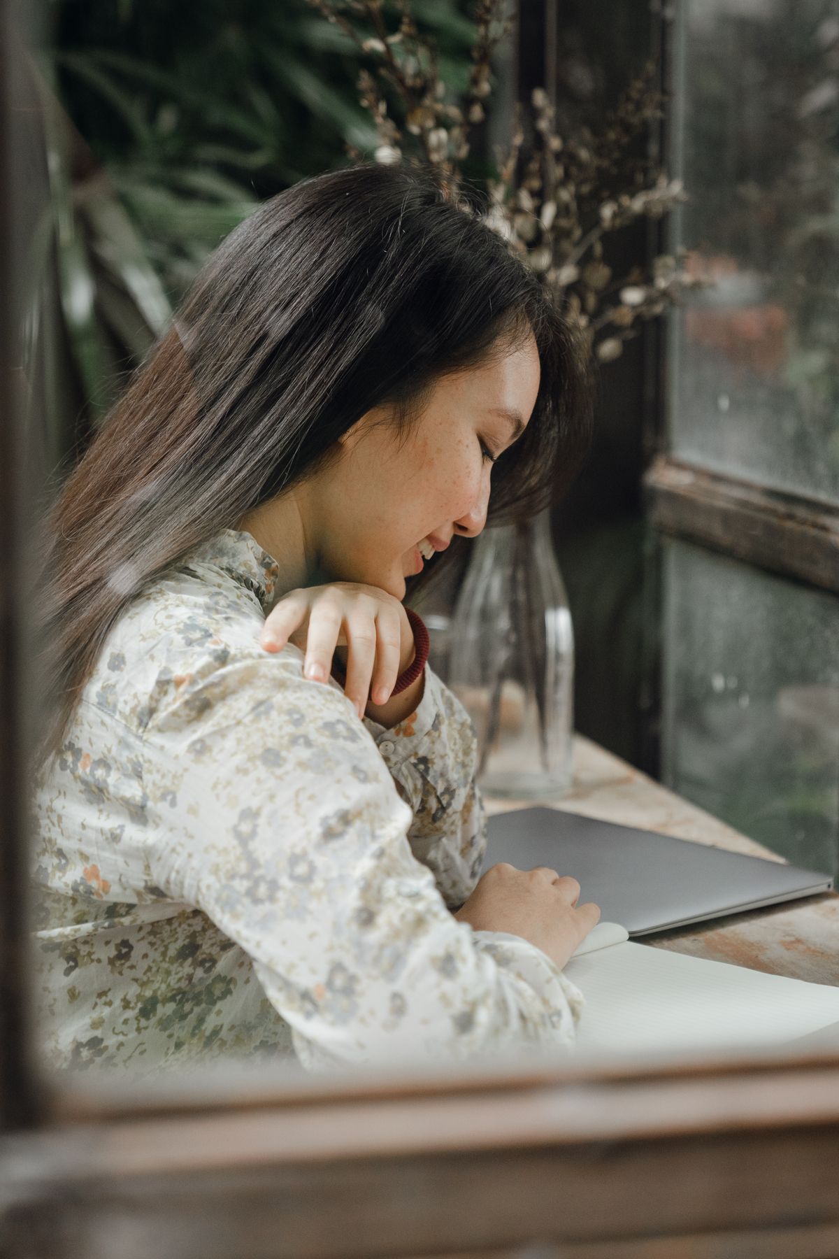 A student reviewing notes by a café window