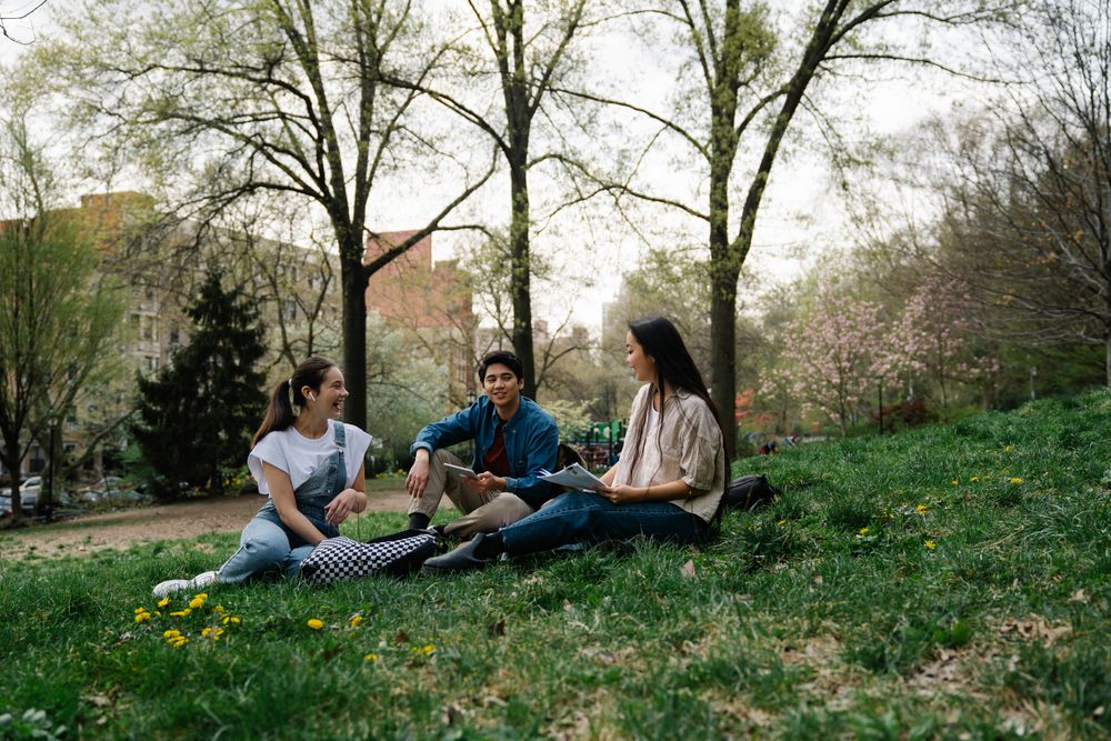 Friends chatting together on a campus lawn
